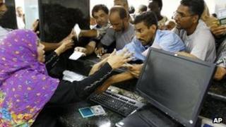 Libyans try to get cash from their accounts at a bank in Tripoli. File photo