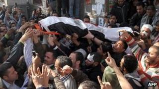 Mourners carry the body a protester killed in clashes in Cairo (19 December 2011)