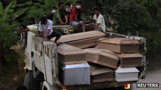 Coffins containing typhoon victims are carried on a truck in Iligan city, southern Philippines (20 Dec 2011)