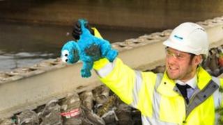 Matt Thompson from Yorkshire Water holds up a cuddly toy in front of a sewer