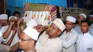 Relatives of one of the people who drowned on Sunday night carry a casket with the remains of his body for burial in Lamu