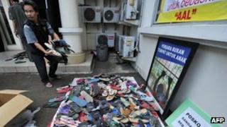 An official from Indonesia's Child Protection Commission carries sandals they received by package at their office in Jakarta