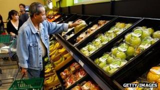 A shopper selecting fruit