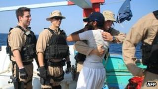 A sailor assigned to the USS Kidd greets a crew member of the Iranian-flagged fishing dhow Al Molai after the US team apparently freed the fishermen from Somali pirates holding them in the Arabian Sea. Image supplied by US Navy