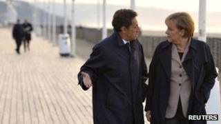 French President Nicolas Sarkozy and German Chancellor Angela Merkel walk near the sea in Deauville, France, October 2010