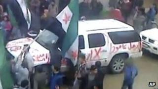 Image made from amateur video purportedly showing graffiti on an Arab League observer vehicle reading "Leave" in al-Hasaka, Syria