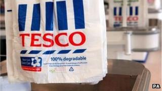 Tesco carrier bags hanging at a checkout