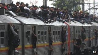 File photo: Passengers on top of a crowded commuter train in Jakarta