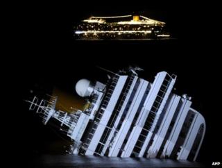 The Costa Serena cruise ship (background) passes the wreck of its sister ship, the Costa Concordia, off Giglio, Italy, 18 January