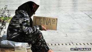 Greek woman holds a sign saying "I'm hungry"