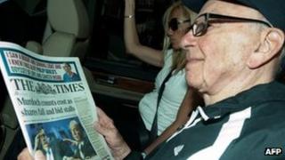 Rupert Murdoch holding a copy of the Times