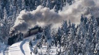 A narrow-gauge railway makes its way through a snow covered forest at the Harz national park near Schierke, central Germany