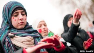 Protesters apply red paint to their hands outside the Syrian embassy in London