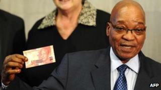 Jacob Zuma shows a new banknote bearing the image of Nelson Mandela