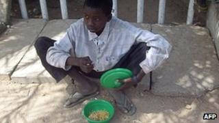 Нищий ребенок получает еду в Кано, Нигерия (снимок из архива)