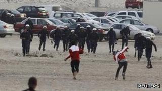 A protester throws a rock at riot police near Farooq Junction, formally known as Pearl Roundabout, west of Manama (13 February 2012)