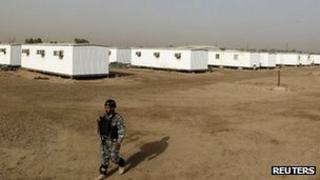 An Iraqi soldier stands guard in the former US military Camp Liberty outside Baghdad which will be the new temporary home for the People's Mujahideen Organisation of Iran (PMOI) exiles