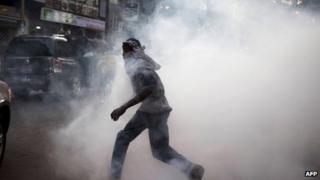 An anti-government protestor flees from tear gas at a protest in Senegal"s capital Dakar, February 21, 2012