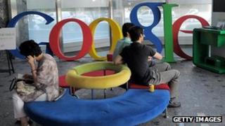Люди сидят на диване перед логотипом Google