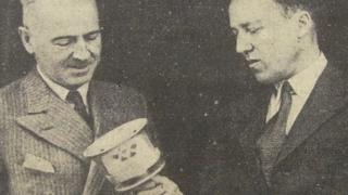 Cdr Collins shows the torch to the Mayor of Torquay, Denys Gilley