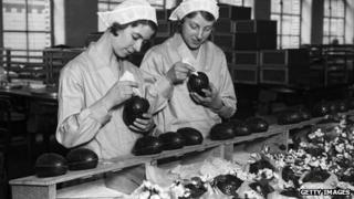 Two women at Cadbury's chocolate factory in Bournville, in the West Midlands join together chocolate Easter egg halves in 1932. Photo: Getty Images