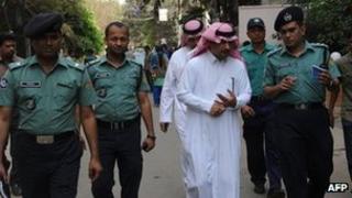 Bangladeshi policemen and Saudi officials inspect the area where a Saudi Arabian diplomat was shot dead in Dhaka