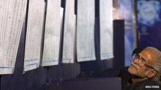 A man look at lists of candidates for the parliamentary election in a mosque in north central Tehran