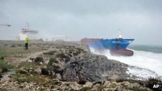 A helicopter hovers near the Gelso M as it sits aground on the Sicilian coast near Syracuse, 10 March