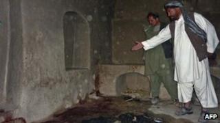 A man points to bloodstains in a room in a house in Alkozai, Kandahar province, Afghanistan, 11 March