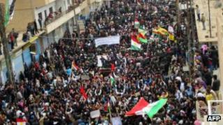 Syrians, some holding up the Kurdish flag, at a protest in Qamishli, Syria on 12 March
