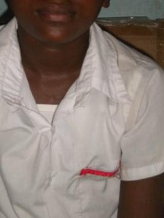 A pupil wearing a red ribbon on the pocket of his uniform