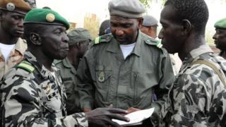 Лидер малийской хунты капитан Амаду Саного (слева) беседует со своими товарищами-солдатами в военном лагере Кати в пригороде Бамако 22 марта 2012 года
