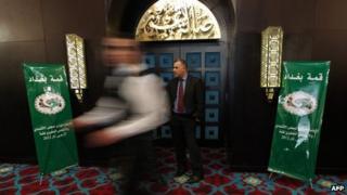 A man walks past a security guard at the venue of a meeting of Arab League finance ministers in Baghdad (27 March 2012)