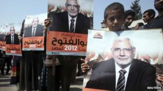 Supporters hold up posters of Abdul Moneim Abu al-Futuh