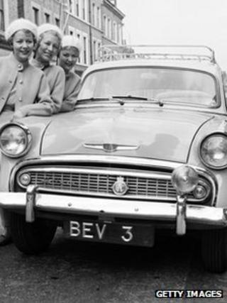 Women stand next to car with personalised number plates in June 1958