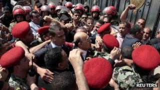 Egypt's former vice president Omar Suleiman (C), is mobbed at the Elections Commission (HPEC) headquarters in Cairo, 8 April 2012