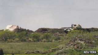 A Syrian tank takes position as seen from the Wadi Khalid area near the Syrian border, in northern Lebanon April 12, 2012