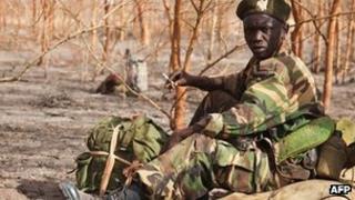 Photo taken on 15 April 2012 of a South Sudanese soldier waiting amongst acacia trees at the front line just north of Heglig