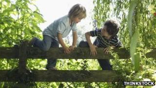 Boys climb a fence