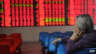Investor looking at share price board