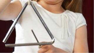 Girl playing triangle