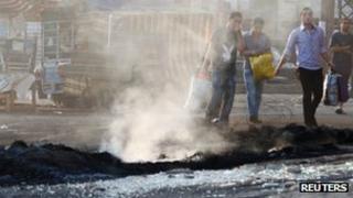 Residents carry their belongings as they flee their homes through smoke from burnt barricades at the Sunni Muslim Bab al-Tebbaneh neighbourhood in Tripoli, northern Lebanon, May 13, 2012