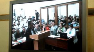 Witness testifying at the trial in Aktau as seen from a television screen