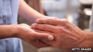 A nurse holding a patient's hand