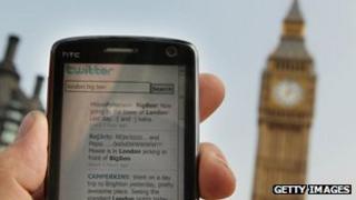 A smartphone displaying a Twitter feed with Big Ben in the background