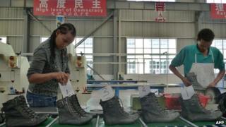 На снимке, сделанном 19 апреля 2012 года, изображены люди, работающие на конвейере на обувной фабрике Huajian в Дукеме, Эфиопия.