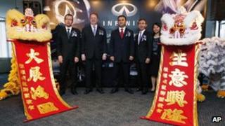 Carlos Ghosn, centre, poses with other Nissan executives during the opening ceremony for the new headquarters of its upscale Infiniti brand