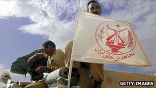 An MEK member displays the group's flag