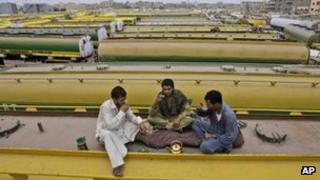 Pakistani drivers drink tea on top of an oil tanker, which was used to transport Nato fuel supplies to Afghanistan but is now parked with other tankers in a compound in Karachi. June 4 2012