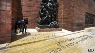 Israeli workers clean anti-Zionist Hebrew graffiti from Yad Vashem